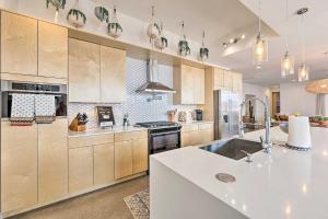 una cucina con armadi in legno e piano di lavoro bianco di Convenient Phoenix Home with Heated Pool and Grill! a Phoenix
