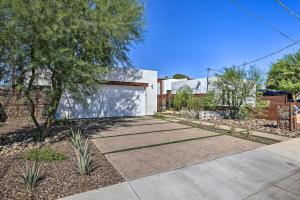 a backyard with a white house and a driveway at Convenient Phoenix Home with Heated Pool and Grill! in Phoenix