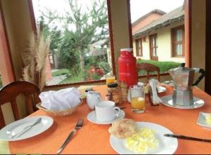 - une table avec de la nourriture pour le petit-déjeuner et une fenêtre dans l'établissement Miskiwasi Bed & Breakfast, à Yanque