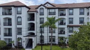 ein Apartmenthaus mit einer Palme davor in der Unterkunft Vista Cay Resort in Orlando
