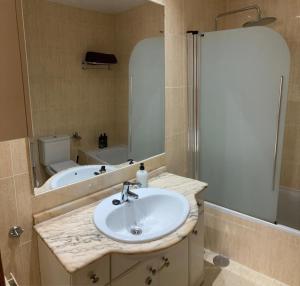 a bathroom with a sink and a tub and a mirror at Apartamento grande, 2 dormitorios, garaje gratis in Madrid