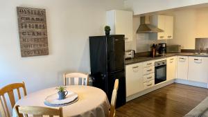 a kitchen with a table and a black refrigerator at City Centre Bridge Street Apartment in Kirkwall