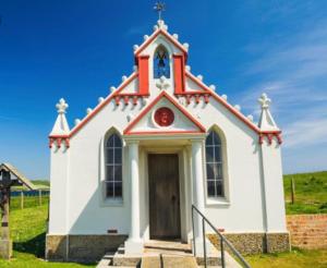 a small white church with a red roof at City Centre Bridge Street Apartment in Kirkwall