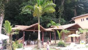 un palmier devant une maison dans l'établissement Pousada Recanto dos Tangaras, à Juqueí