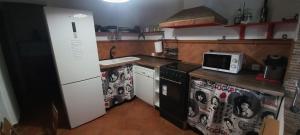 a kitchen with a stove and a microwave at Casa De Campo Azul En Antequera in Antequera