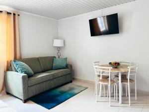 een woonkamer met een bank en een tafel bij Aruba Bliss Condos in Oranjestad