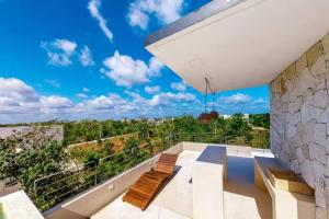 uma varanda com dois bancos e um céu azul em 301 Amena Spacious Penthouse private Pools and View em Tulum