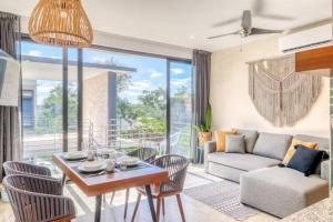 uma sala de estar com uma mesa e cadeiras e um sofá em 301 Amena Spacious Penthouse private Pools and View em Tulum