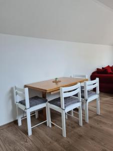 a dining room table and chairs with a couch at Gîte de la Gourgeonne in Nervezain +9 photos
