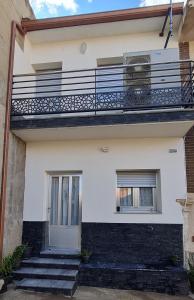 a house with a balcony and stairs at El Patio Grande in Menasalbas