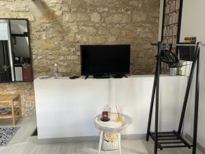 una sala de estar con TV en un mostrador blanco en Studio centre ville, en Compiègne