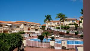 a view of the pool at a resort with palm trees at Atico Carlota- Feel Canarias ! in Chayofa