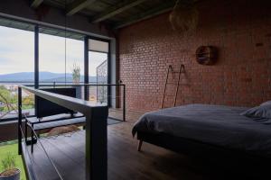 a bedroom with a brick wall and a bed and a balcony at Апартаменты True Love с видом на горы in Uzhhorod