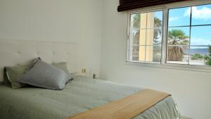 a bed in a white room with a window at Atico Carlota- Feel Canarias ! in Chayofa +34 photos
