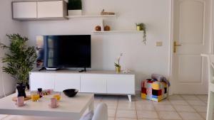 a living room with a tv on a white cabinet at Atico Carlota- Feel Canarias ! in Chayofa