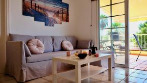 a living room with a couch and a table at Atico Carlota- Feel Canarias ! in Chayofa