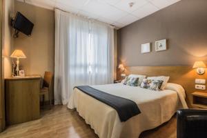 a hotel room with a bed and a window at Hotel Casa Jacinto Pamplona in Burlada