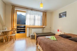 1 dormitorio con 2 camas, mesa y ventana en Willa Strumyk, en Zakopane