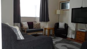 uma sala de estar com um sofá e uma televisão em Bubblesbnb 7 Bedroom House, 16 beds, sleeps 22 em Londres