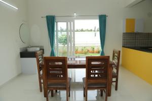 a kitchen with a table and chairs and a window at The best villa stay- family friendly in Coimbatore
