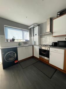 a kitchen with a washer and dryer in it at Tilbury Docks Rooms for Short letting in Tilbury