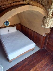 uma pequena cama num quarto com uma parede de madeira em Pepos Xul-Ha em Xul-Ha