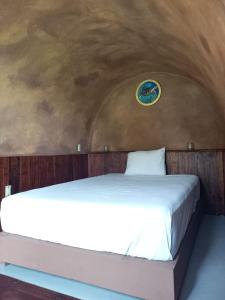 uma cama num quarto com um relógio na parede em Pepos Xul-Ha em Xul-Ha