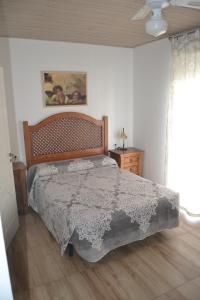 - une chambre avec un grand lit et une tête de lit en bois dans l'établissement Apartamento en Olvera, à Olvera