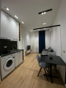 a kitchen and living room with a table and a washing machine at Luxury Apartament in Blloku in front of Taiwan in Tirana