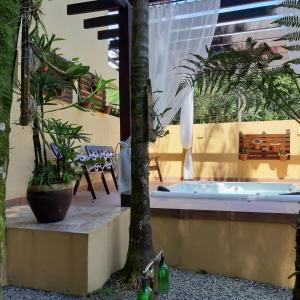 a jacuzzi tub in a courtyard with plants at Pousada Recanto dos Tangaras in Juquei