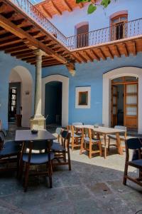 a patio with tables and chairs under a roof at Hotel Azul de Oaxaca in Oaxaca City