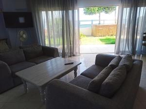 a living room with two couches and a coffee table at Salty Breeze Beachfront by Lefkadastay in Lygia