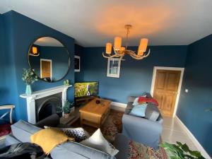 伊辛瓦的住宿－Innkeeper's House，蓝色的客厅配有沙发和镜子