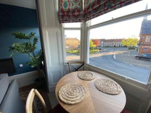 a dining room with a table and a large window at Innkeeper's House in Easingwold