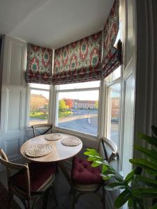 uma mesa e cadeiras num quarto com uma janela em Innkeeper's House em Easingwold