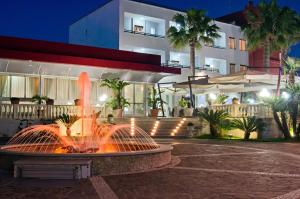a fountain in front of a building at night at Hotel Mediterraneo in Porto Cesareo