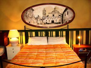 1 dormitorio con 1 cama con una pintura en la pared en B&B Cheap Holidays, en Sorso