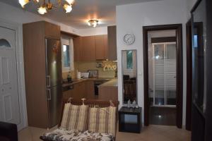 a kitchen with a refrigerator and a table with a clock at IOANNIS SEASIDE VILLA in Leptokarya