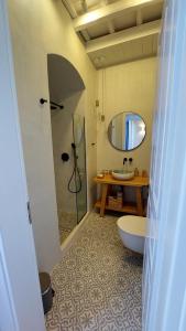 y baño con lavabo, aseo y espejo. en Halki Sea Breeze - a waterfront villa, en Halki