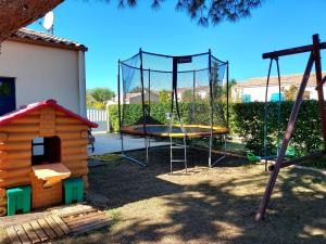 een speeltuin met een trampoline en een schommel bij Maison familiale avec piscine chauffée in Saint-Georges-de-Didonne