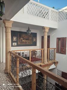 a staircase in a house with a wooden railing at Riad Dar Badiaa in Sale
