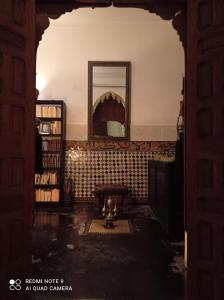 une voûte dans une pièce avec un miroir et des livres dans l'établissement Riad Dar Badiaa, à Sale
