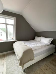 a bedroom with a white bed with a window at Design apartments in the heart of Reykjavik in Reykjavík