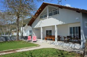 Casa blanca con patio y patio en Belíssima Casa - Pé na areia - Bombinhas - Canto Grande, en Bombinhas
