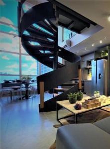 a living room with a spiral staircase in a house at APARTAMENTO Duplex Manhattan com 3 Suites, Casal, Solteiro e Office in Goiânia
