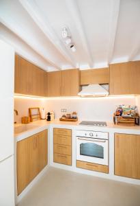 cocina con armarios de madera y horno blanco en Villa Nima, en Klouvas