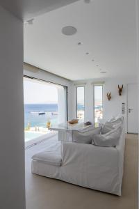 uma sala de estar com um sofá branco e vista para o oceano em Villa Nima em Klouvas