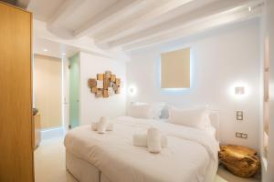 a white bedroom with a large white bed with white pillows at Villa Nima - 2 Bedroom Villa with Private Pool & Sea View, Mykonos Town in Klouvas