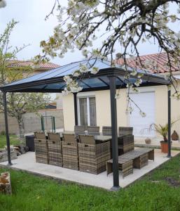 a gazebo with chairs and a bench under it at Chambre privée chez Les Maisons Loli'days in Saint-Médard-en-Jalles