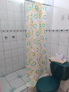 a shower curtain in a bathroom with a toilet at Hostal Los Flamencos in Puerto Villamil